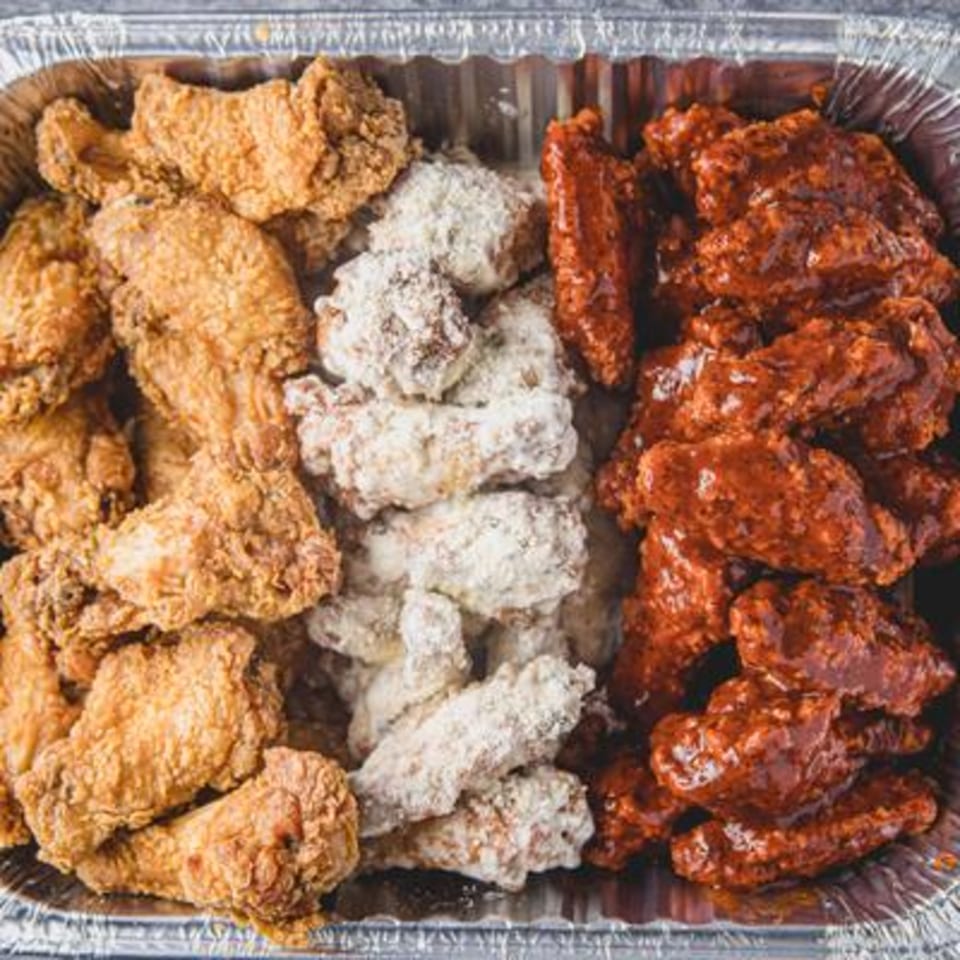 A catering tray of Bonfire Wings with three flavors: plain, lemon pepper, and BBQ.